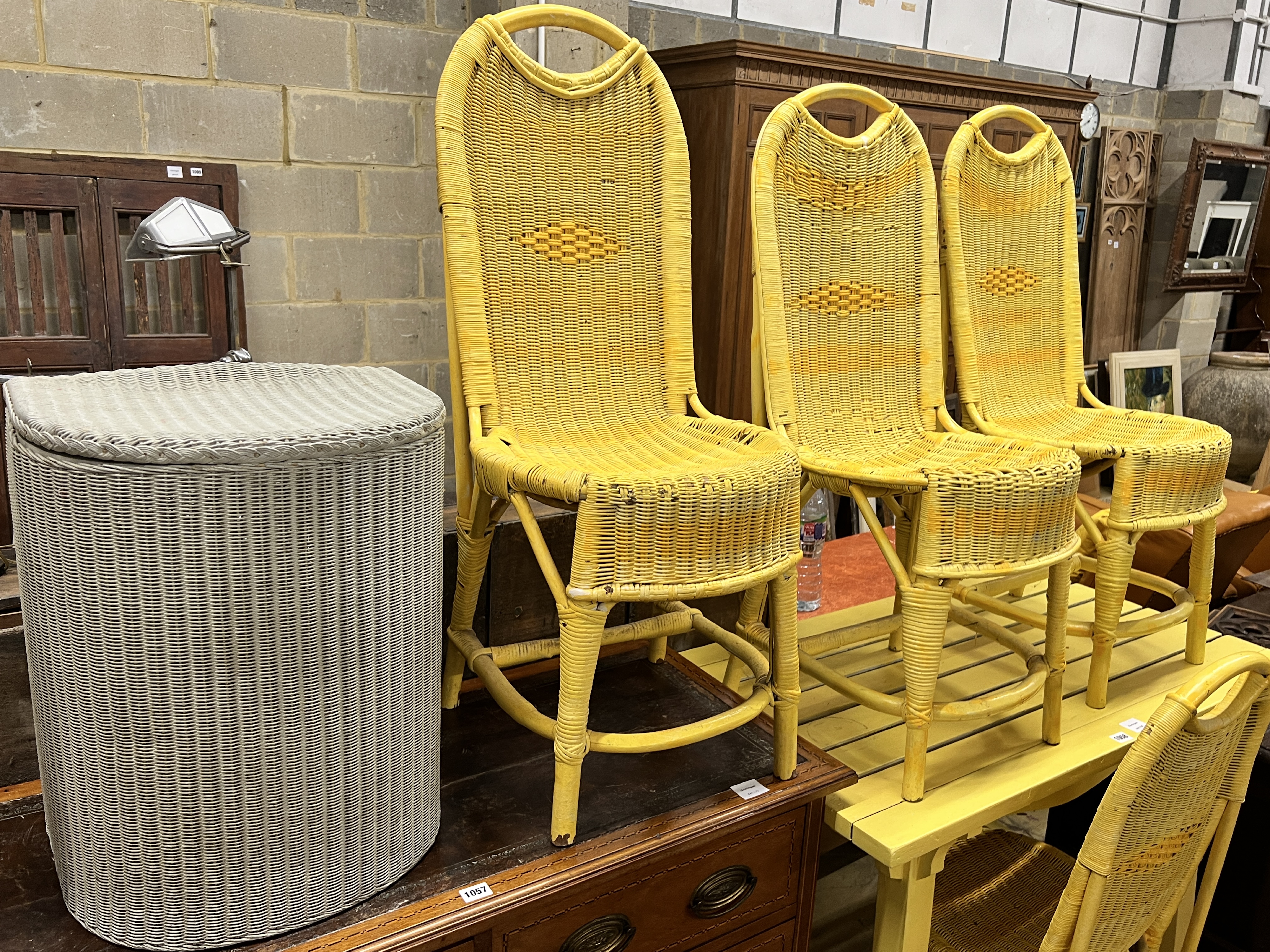 A yellow painted slatted wood rectangular garden table, length 107cm, depth 61cm, height 74cm, four painted Lloyd Loom chairs and a laundry basket